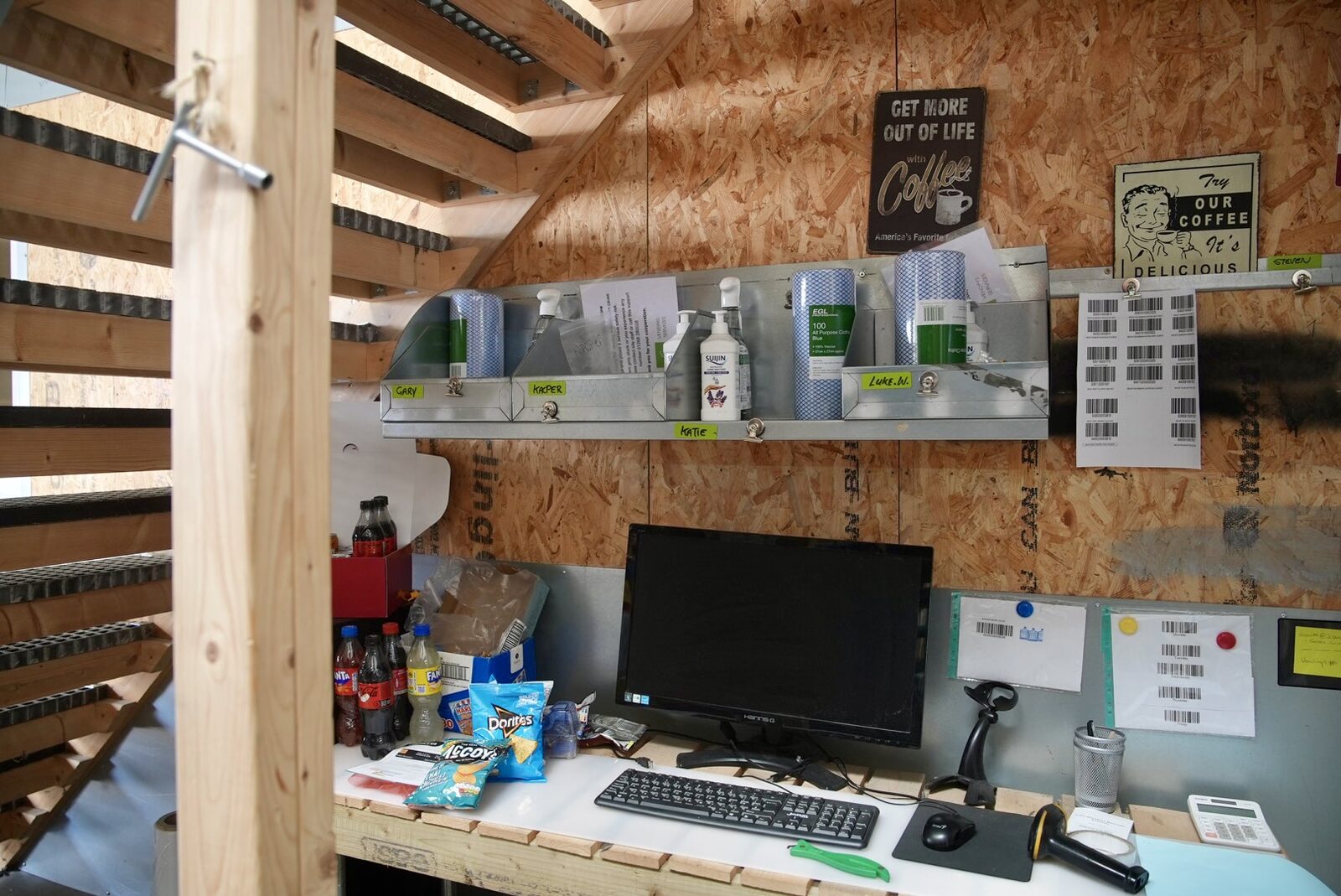 Goods-in workstation at LC Vending Solutions — named engineer cubbies labelled Gary, Harper, Artie and Lukas Jr.