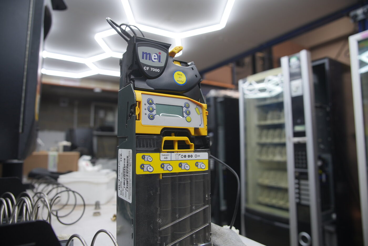 MEI CF7000 cash collector being calibrated on the workshop bench — payment systems we maintain in-house.
